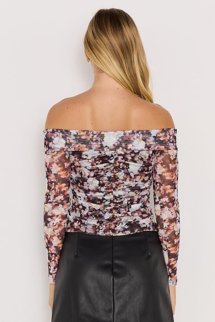 Woman wearing a floral off-shoulder top against a white background