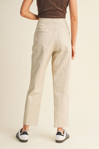 Person wearing beige pants on a plain background