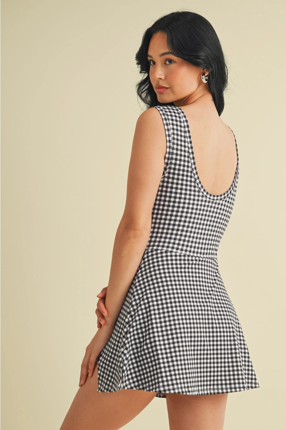 Woman wearing a black and white checkered dress on a beige background