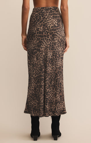 Person wearing a leopard print skirt on a beige background