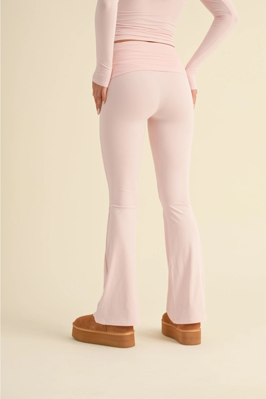 Person wearing light pink leggings with brown platform shoes on a beige background