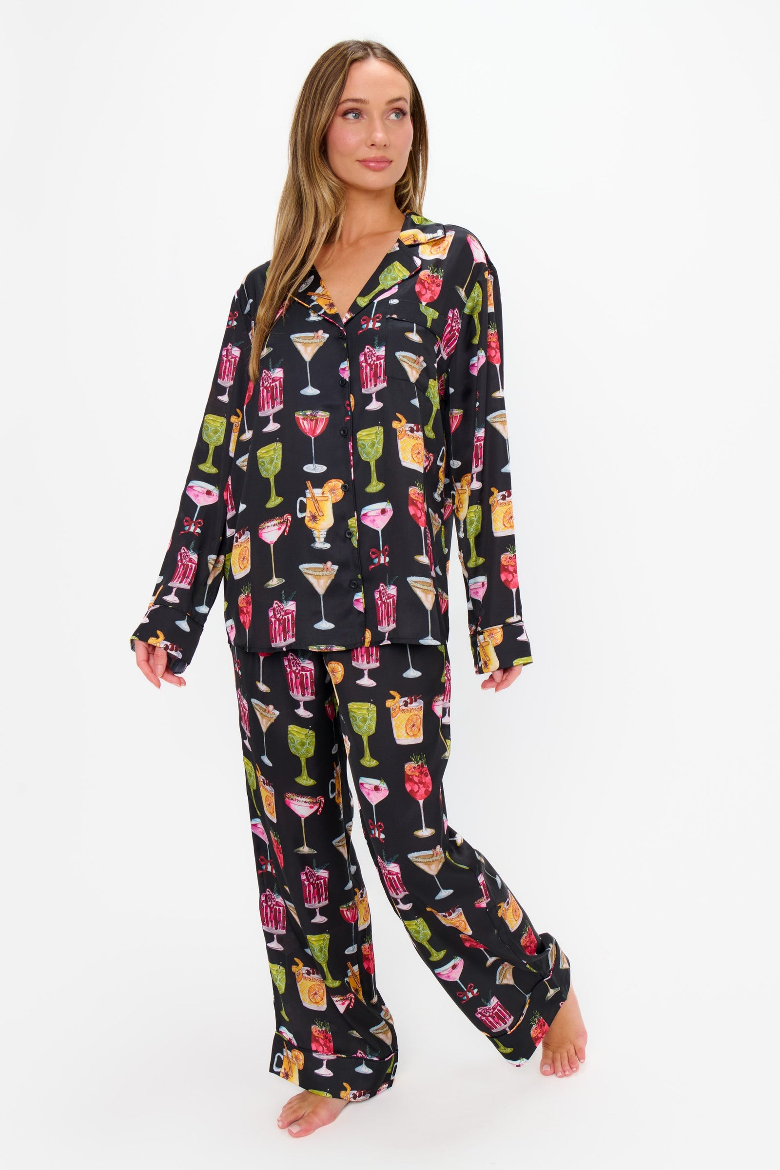 Woman wearing a colorful pajama set with cocktail graphics on a white background