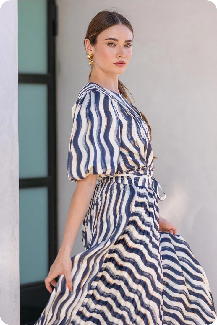 Woman wearing a blue and white striped dress against a neutral background