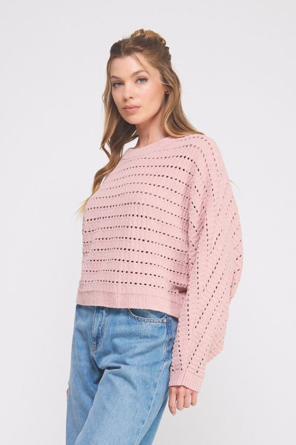 Woman wearing a pink sweater and blue jeans on a white background