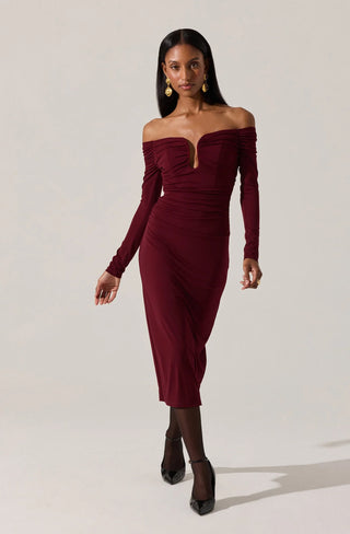 Woman wearing a burgundy off-shoulder dress against a white background