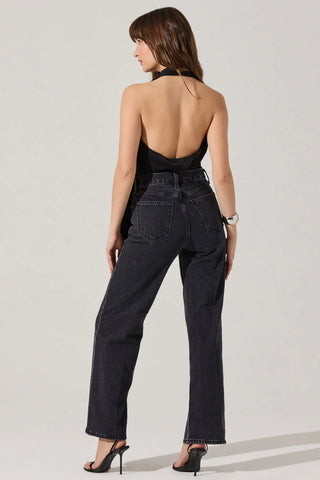 Woman wearing a black jumpsuit with a halter top on a white background