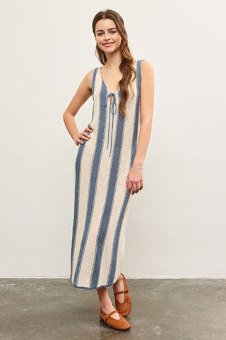 A woman standing, wearing a blue and white striped dress STMT BOUTIQUE 