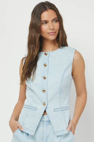 A woman wearing a light blue denim button vest with front pockets STMT BOUTIQUE 