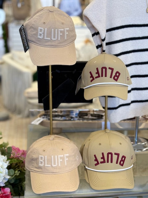 A beige cotton hat with the word 'BLUFF' embroidered in white on the front.