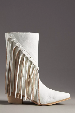 A white western boot with fringe along the shaft, featuring a pointed toe and block heel.
