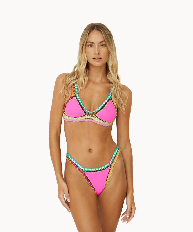 A woman wearing a green, orange, and white geometric patterned bikini STMT BOUTIQUE 