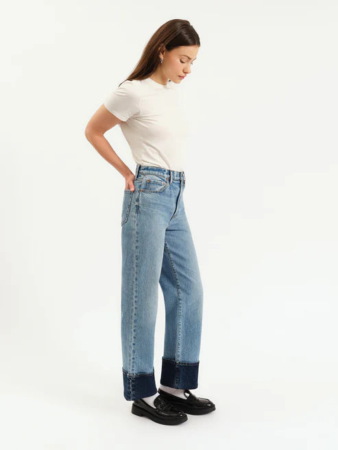 Woman wearing blue jeans with a white background