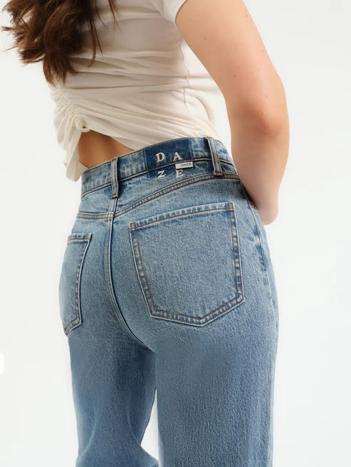 Person wearing light blue jeans with a white background