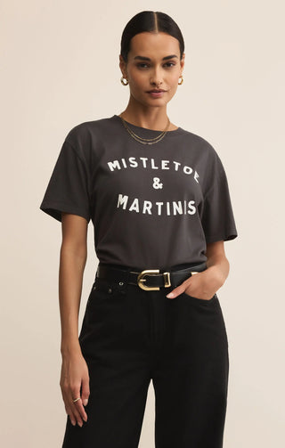 Woman wearing a black t-shirt with 'Mistletoe & Martinis' text on a beige background