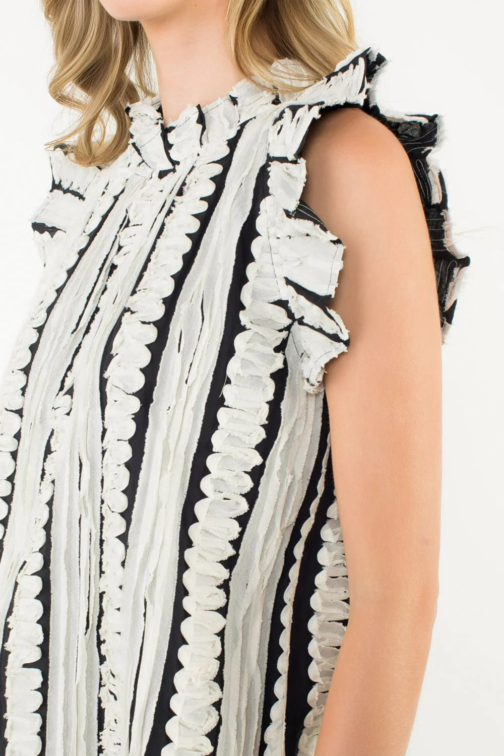 Black and white patterned sleeveless top on a person against a white background
