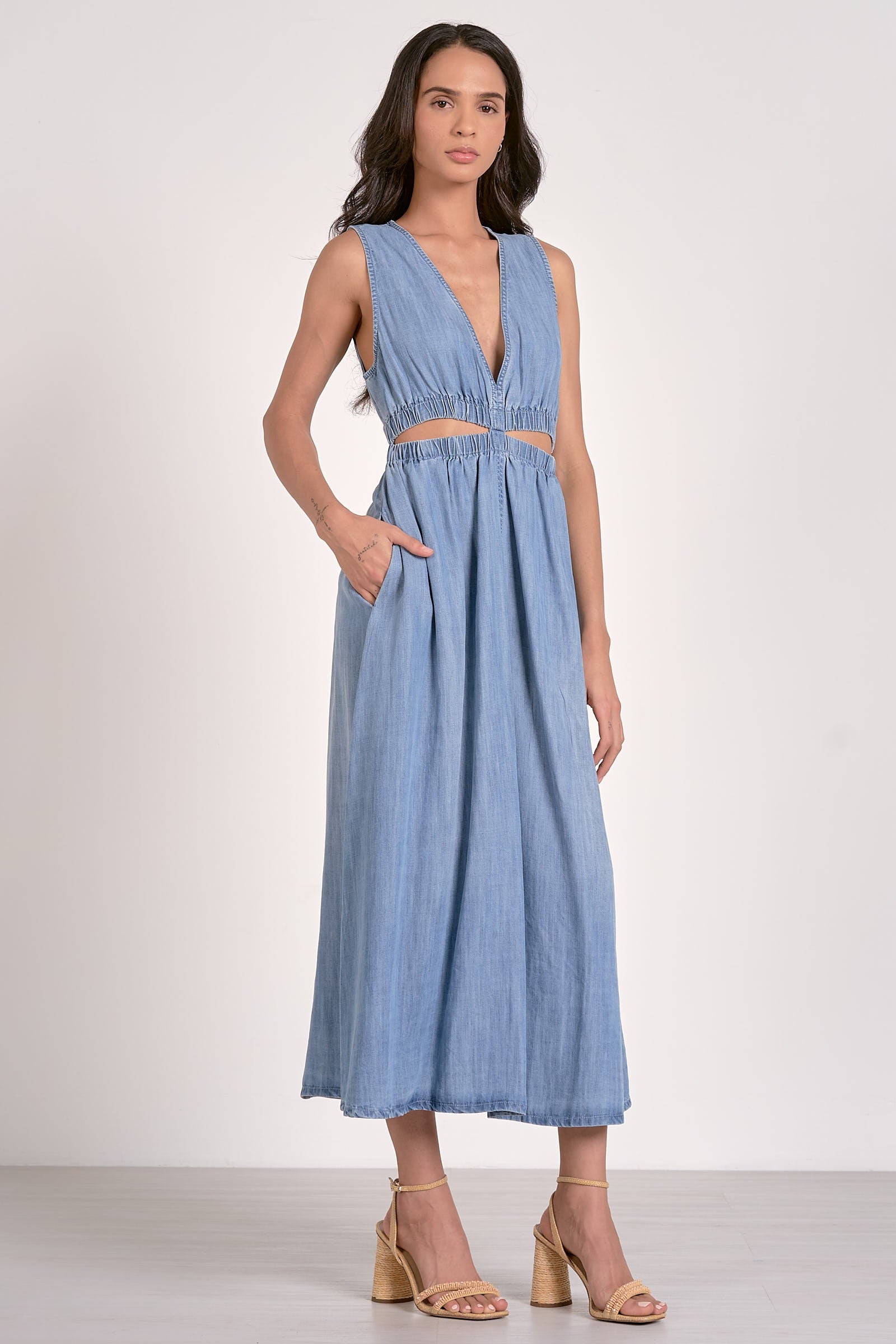 A woman wearing a midi length sleeveless blue dress STMT BOUTIQUE 