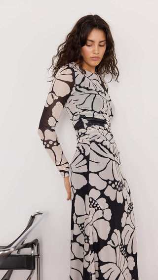 Woman wearing a black and white floral dress against a white background
