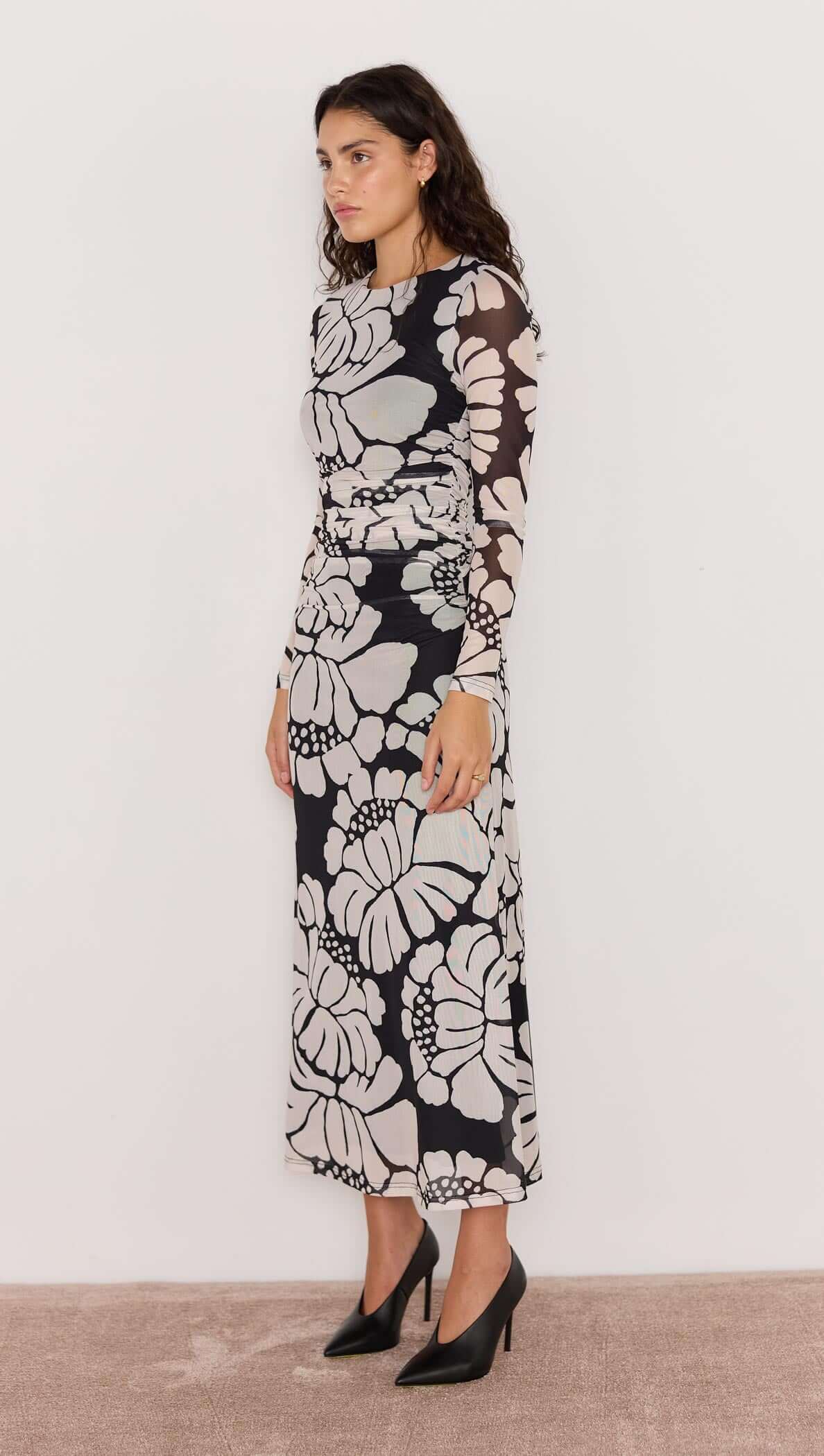 Woman wearing a black and white floral dress against a white background
