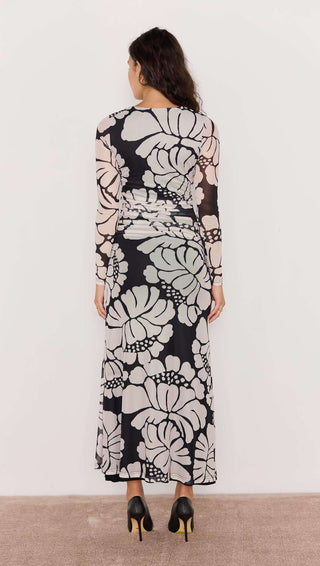 Woman wearing a long floral dress with a white background