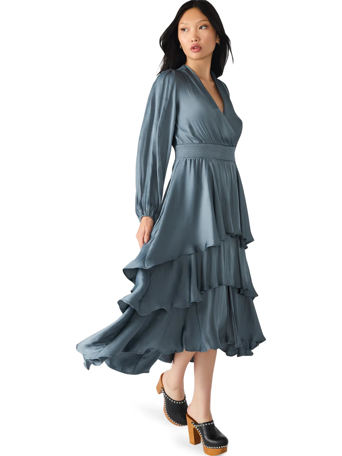 Woman wearing a long, flowing blue dress on a white background