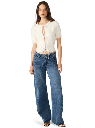 Woman wearing a white top and blue jeans on a white background