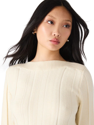 Woman wearing a cream sweater against a white background