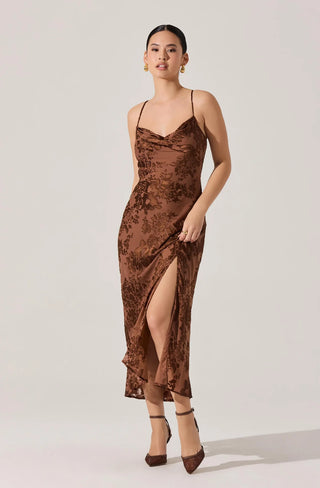 Woman wearing a brown slip dress with a slit on a white background