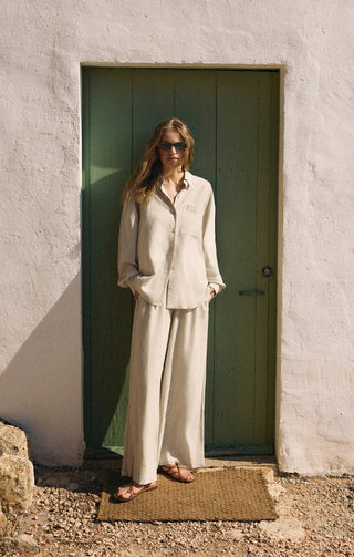 Woman standing in front of a green door on a white wall