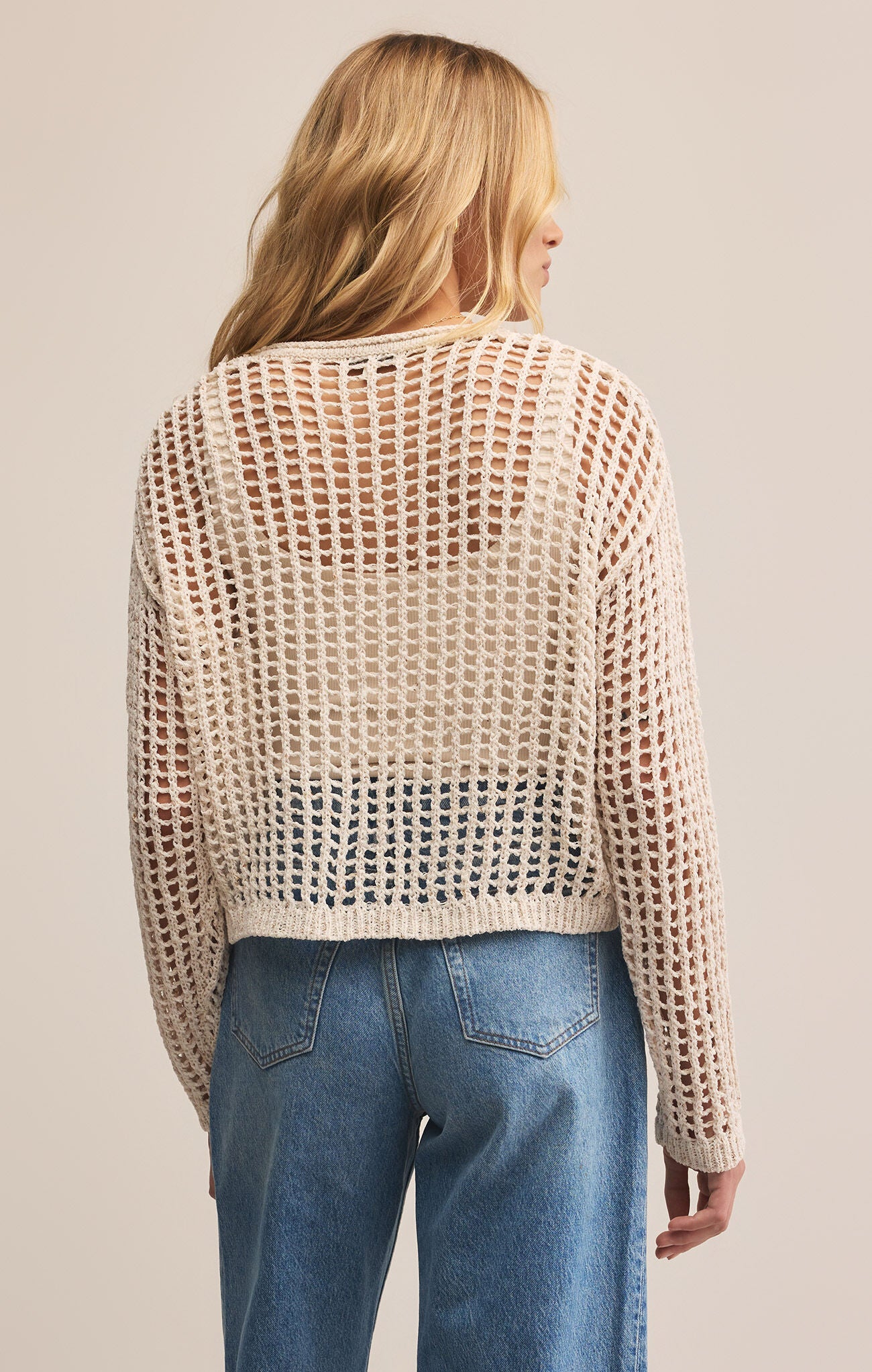 Woman wearing a beige open-knit sweater
