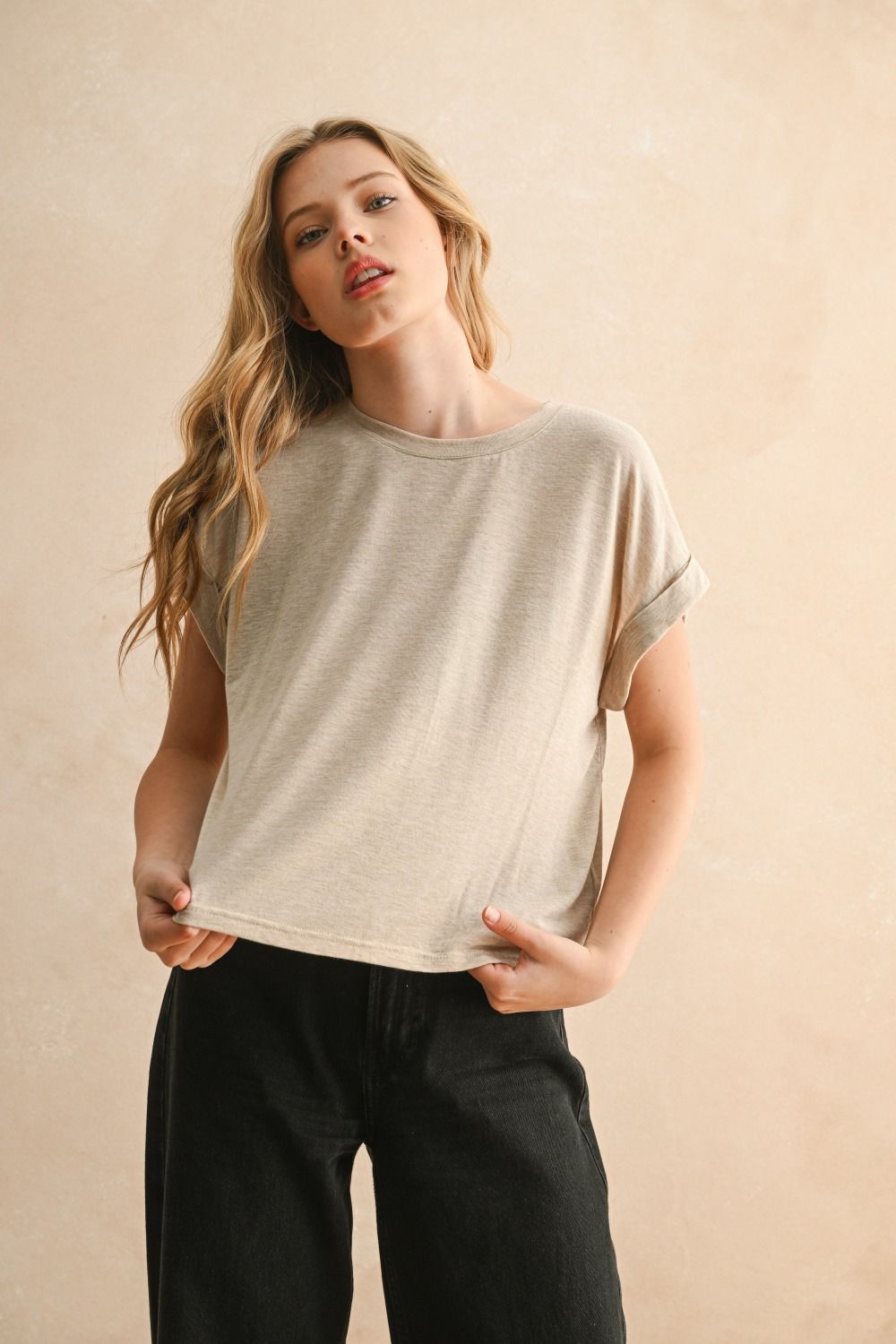 Woman wearing a beige t-shirt and black pants