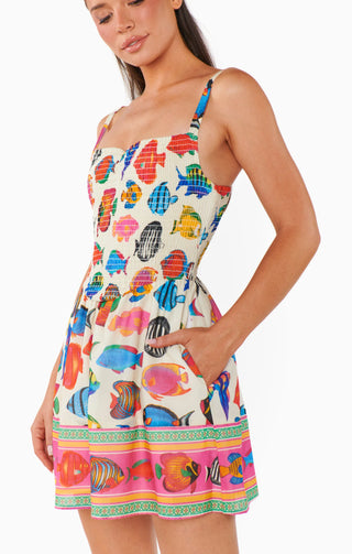 Woman wearing a colorful fish-patterned dress on a white background