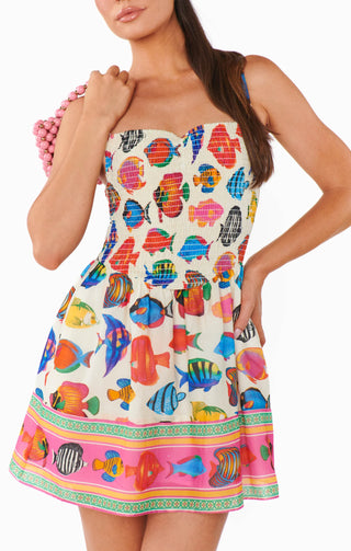 Woman wearing a colorful fish-patterned dress with a white background