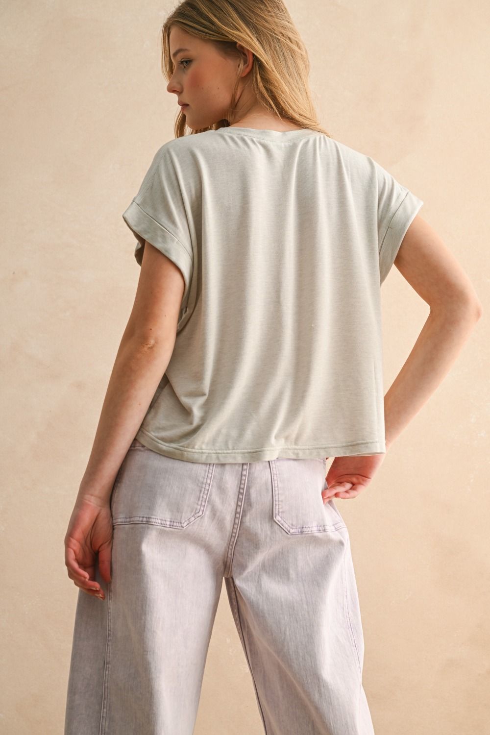 Woman wearing a light-colored t-shirt and jeans