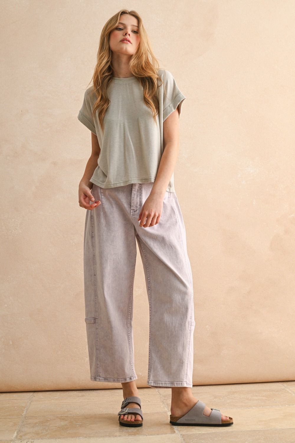 Woman wearing a light-colored t-shirt and wide-leg pants 