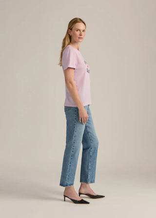 Woman wearing a pink t-shirt and blue jeans 