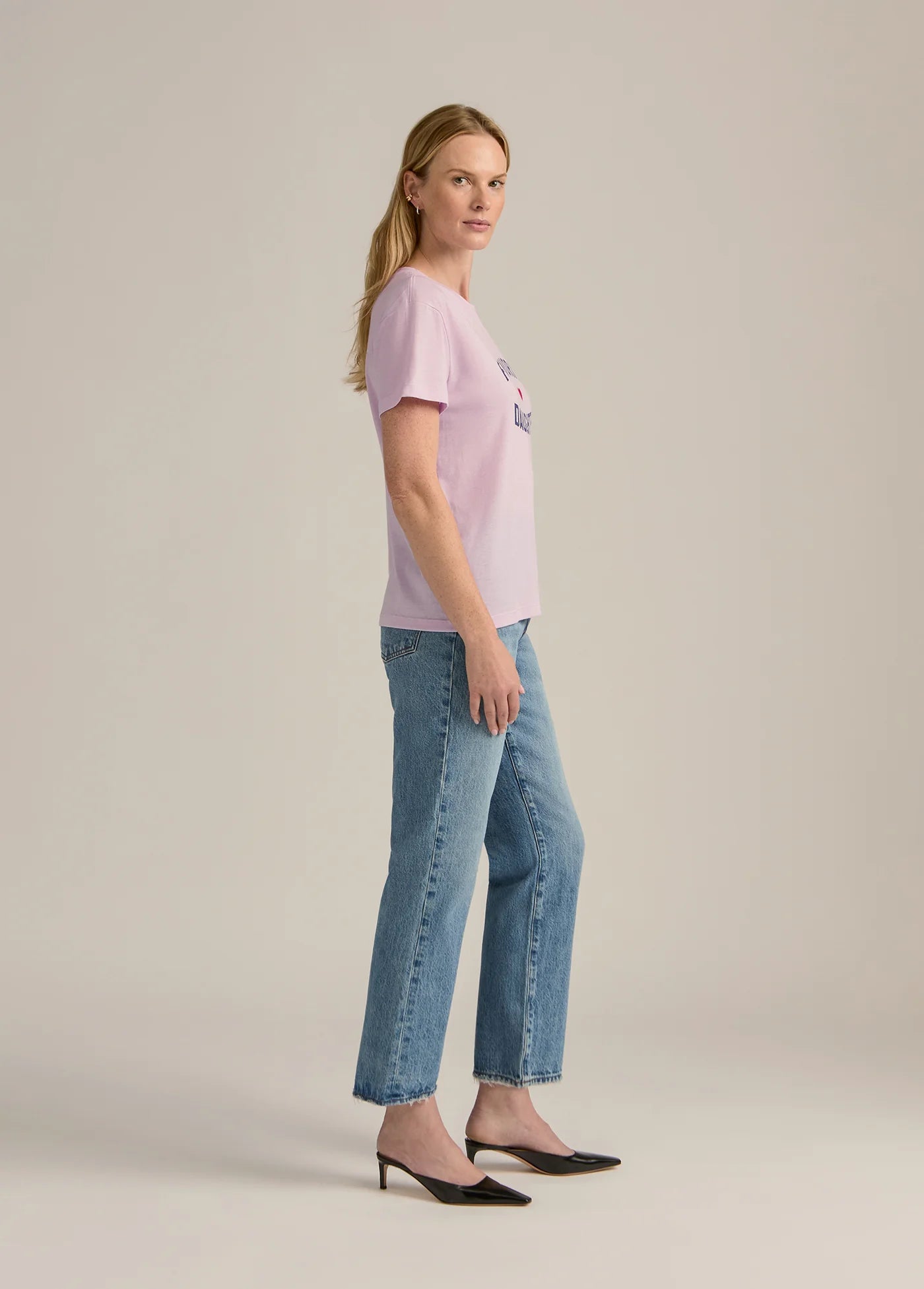Woman wearing a pink t-shirt and blue jeans 