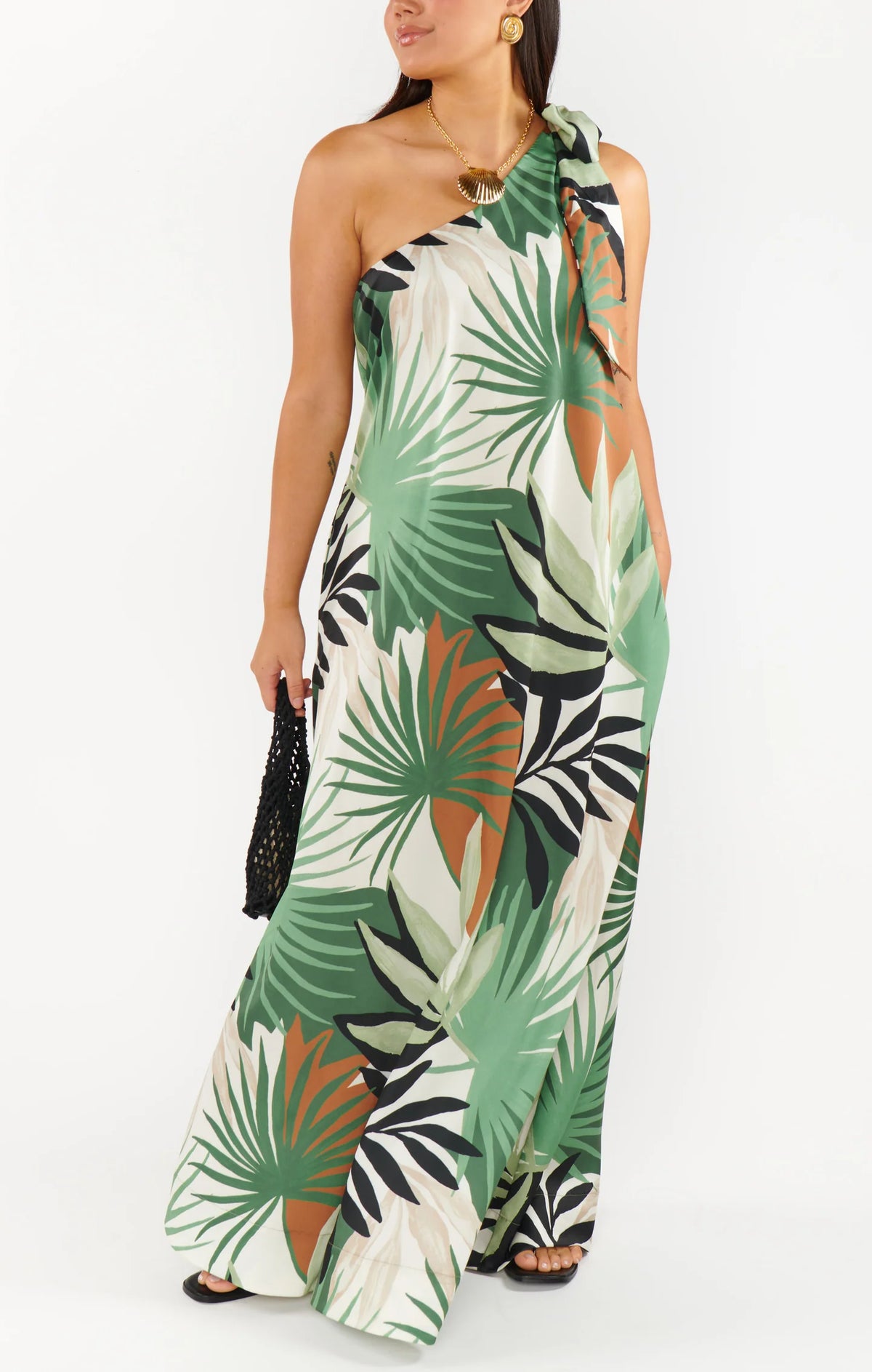 Woman wearing a tropical leaf patterned one-shoulder dress 
