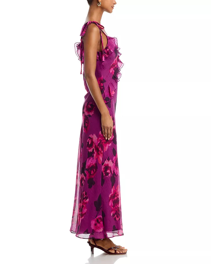 Woman wearing a vibrant purple floral dress on a white background