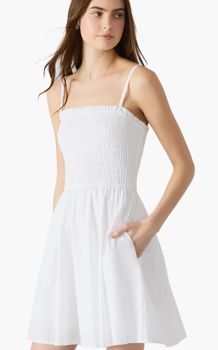 A woman wearing a white sleeveless knee-length dress STMT BOUTIQUE 