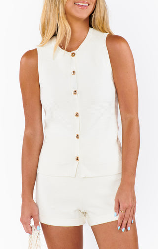 Woman wearing a white sleeveless blazer 