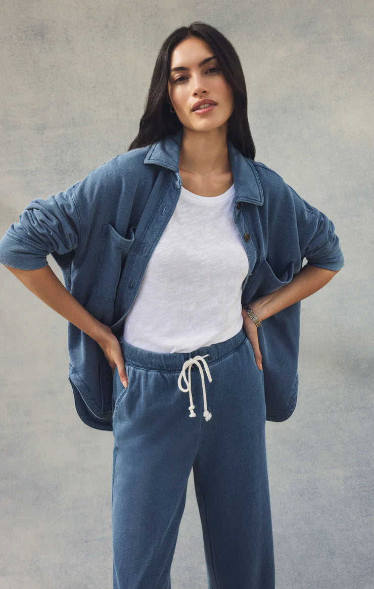 Woman wearing a blue denim outfit with a plain background