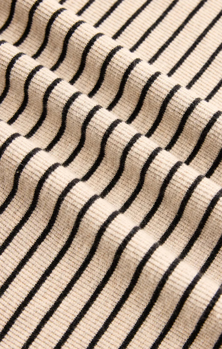 Close-up of a fabric with black wavy lines on a beige background
