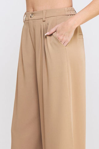 Beige wide-leg pants worn by a person on a white background