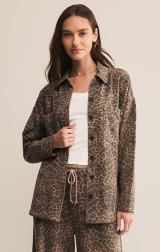 Woman wearing a leopard print jacket and pants on a beige background