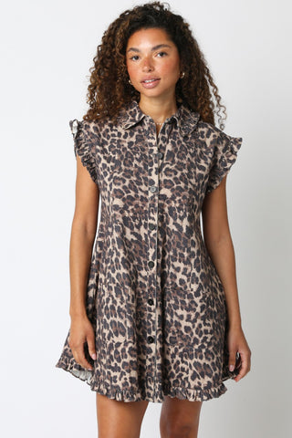 Woman wearing a leopard print dress against a plain background