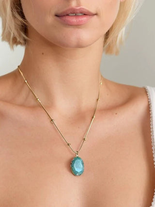 Necklace with a turquoise pendant worn by a person against a neutral background stmt-boutique 