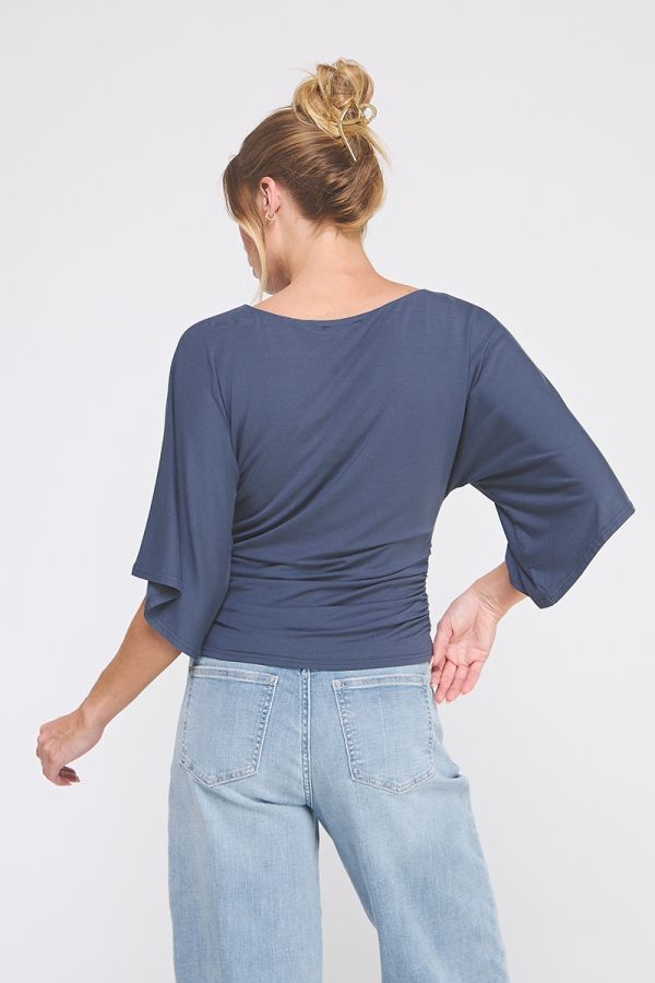 Woman wearing a blue top and light blue jeans on a white background