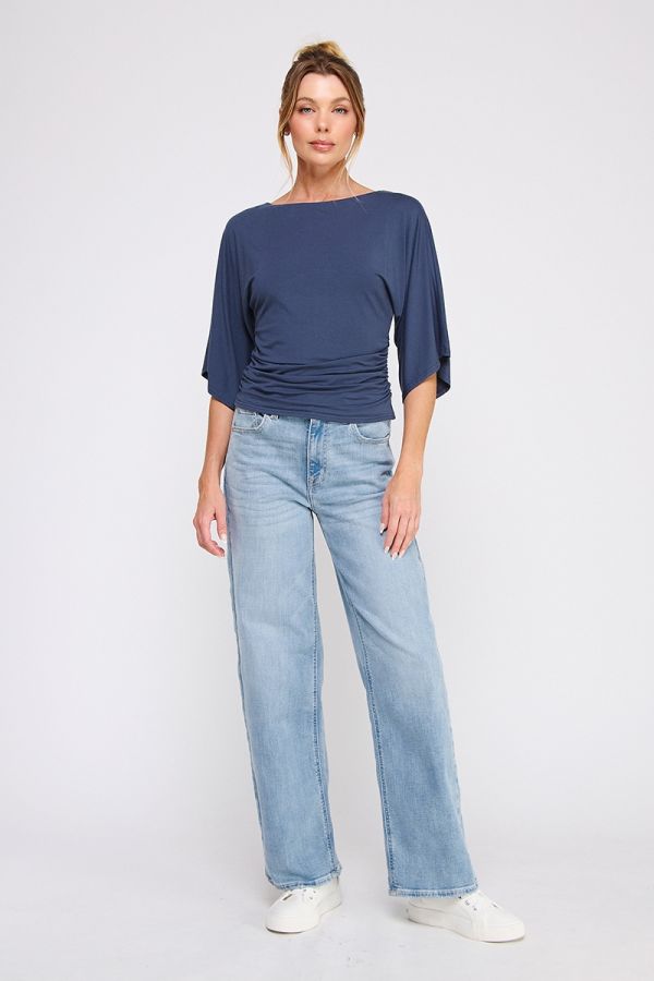 Woman wearing a blue top and light blue jeans on a white background
