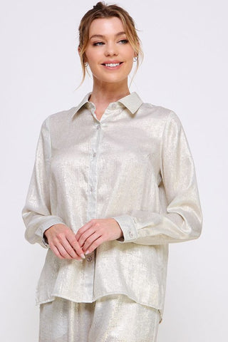 Woman wearing a light-colored blouse with a plain background