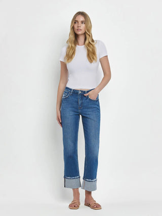 Woman wearing a white t-shirt and blue jeans on a white background